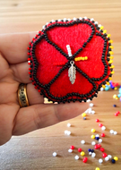 Handcrafted Indigenous beaded poppy pin in red and black beadwork